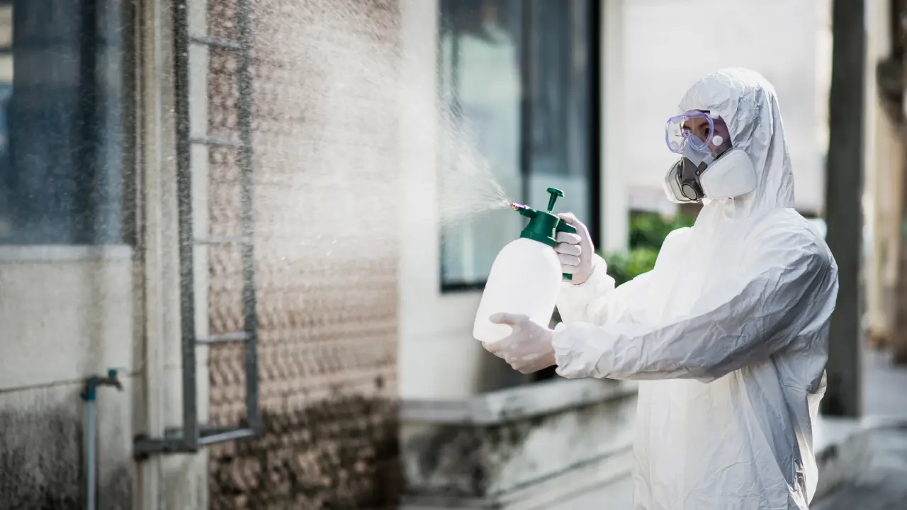 Licensed technician in protective gear treating a home in Cañon City, CO